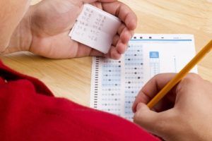 9848694 - student using a cheat sheet to cheat on his test.